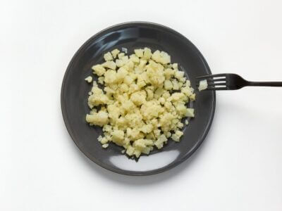 Soft and bite-sized cauliflower on aplate with a fork