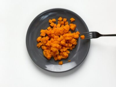 Soft and bite-sized sweet potato on a plate with fork